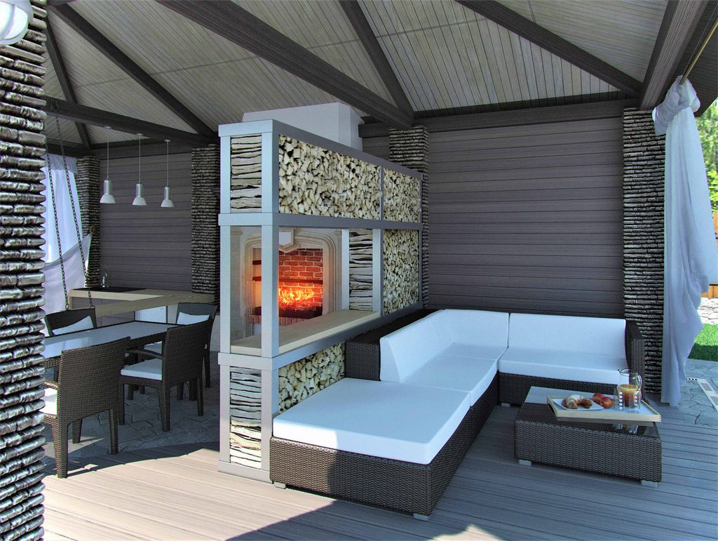 Modern outdoor patio with a fireplace, stacked wood storage, wicker furniture with white cushions, and a small table set with food and drinks.