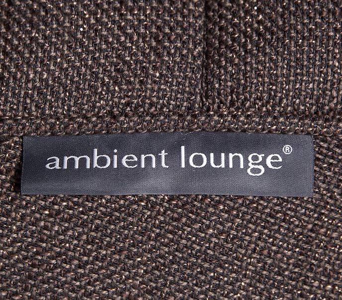 A close-up of a black fabric label with the white text “ambient lounge®” stitched onto a textured brown woven fabric.
