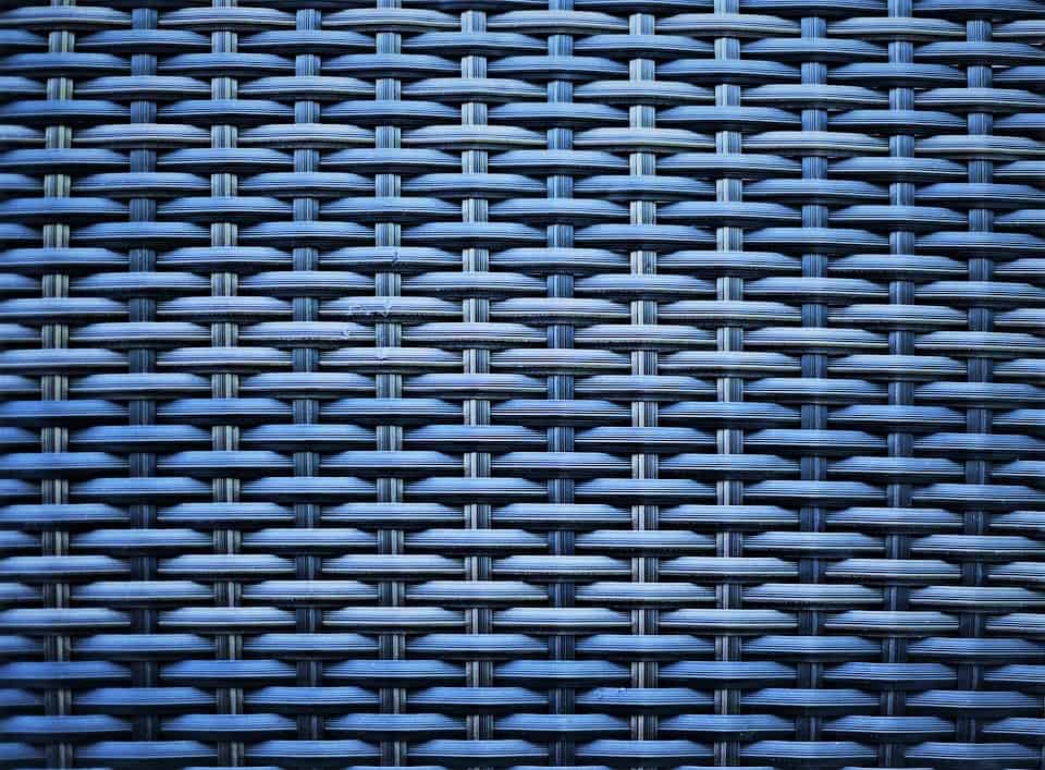 Close-up of a blue woven pattern, likely plastic or synthetic rattan, showing an interlaced grid structure.